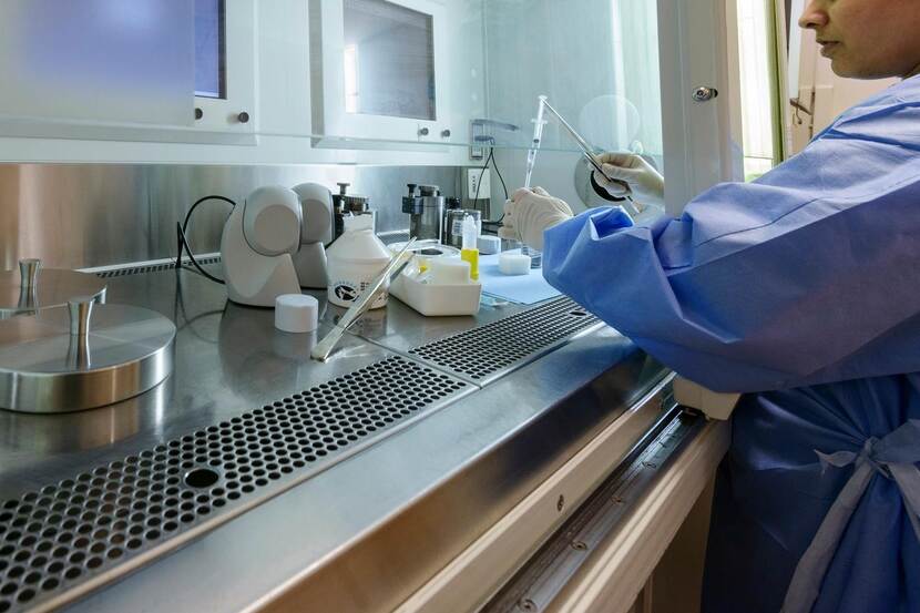 Een laborante bereidt radiofarmaca in een klein laboratorium.